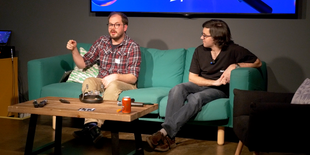 Zappar co-founders Simon Taylor and Connell Gauld sit on a green sofa with Zapbox on the table in front of them answering questions.